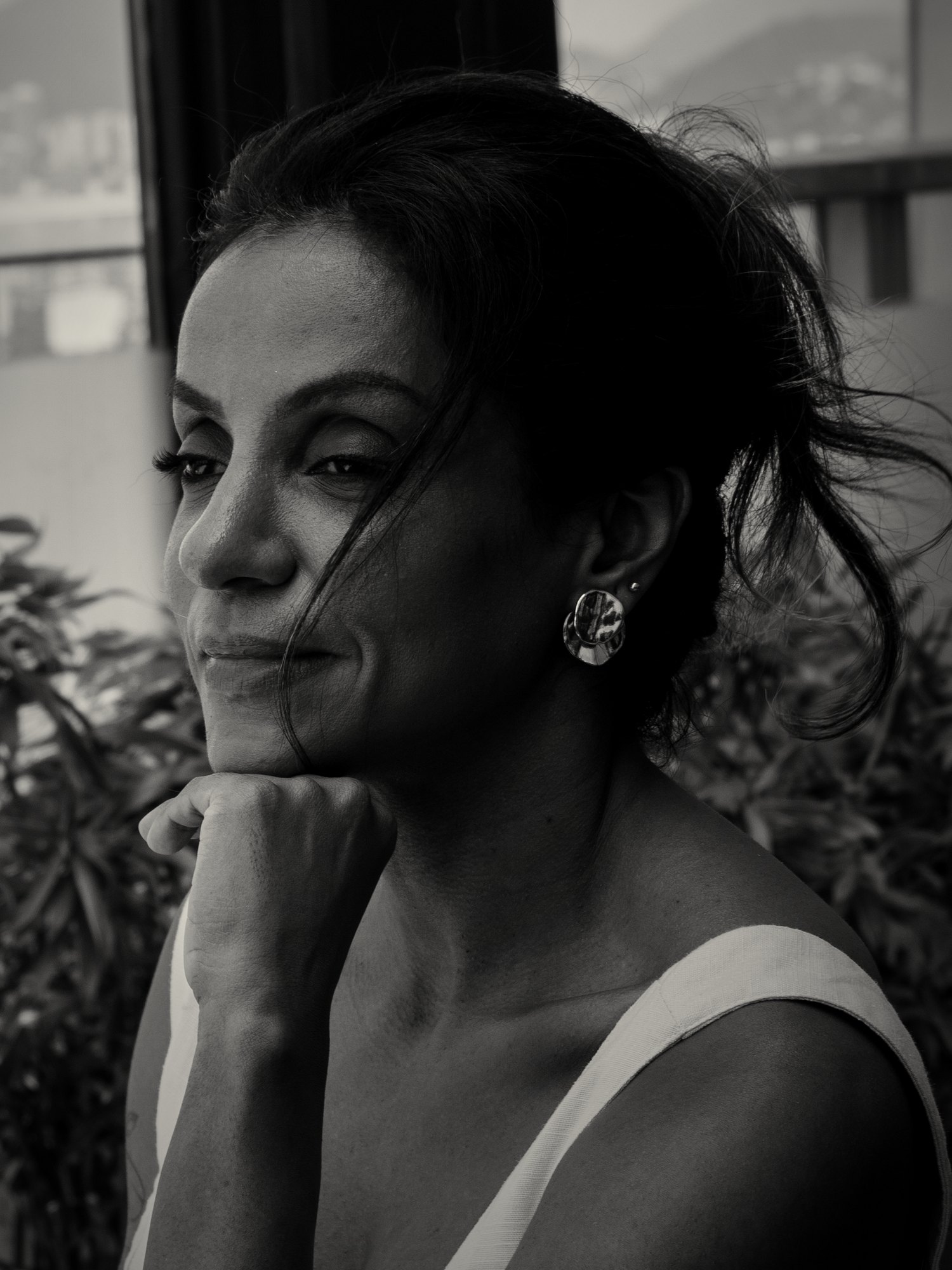 Dra. Marcela Araujo em retrato em preto e dourado, pensativa